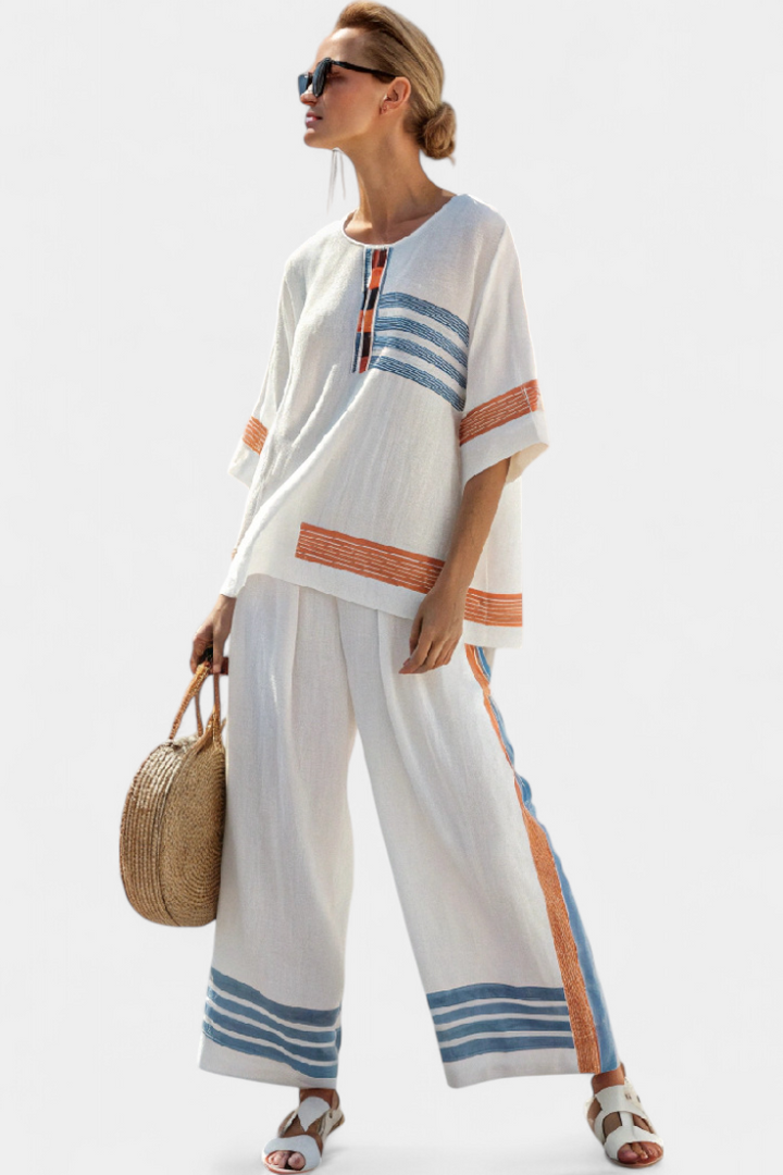 Completo etnico Daisy in bianco con dettagli a righe in blu e arancione – stile unico e vibrante